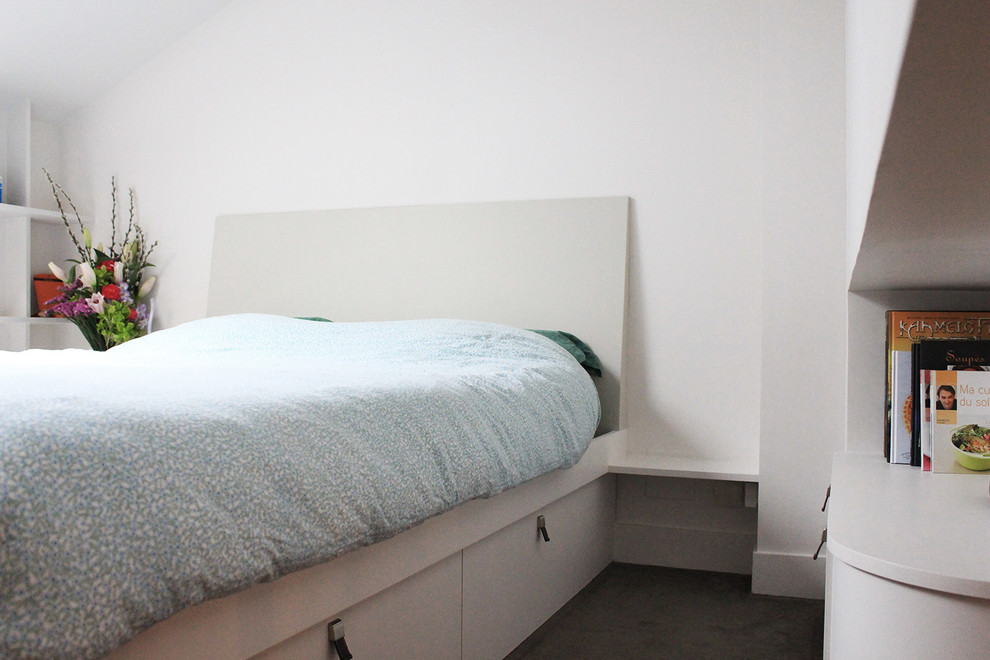 Cette photo montre une petite chambre tendance avec un mur blanc, aucune cheminée et un sol marron.
