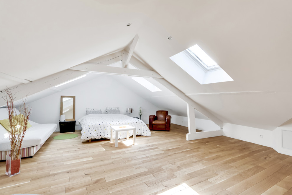 Diseño de dormitorio actual grande con paredes blancas y suelo de madera clara