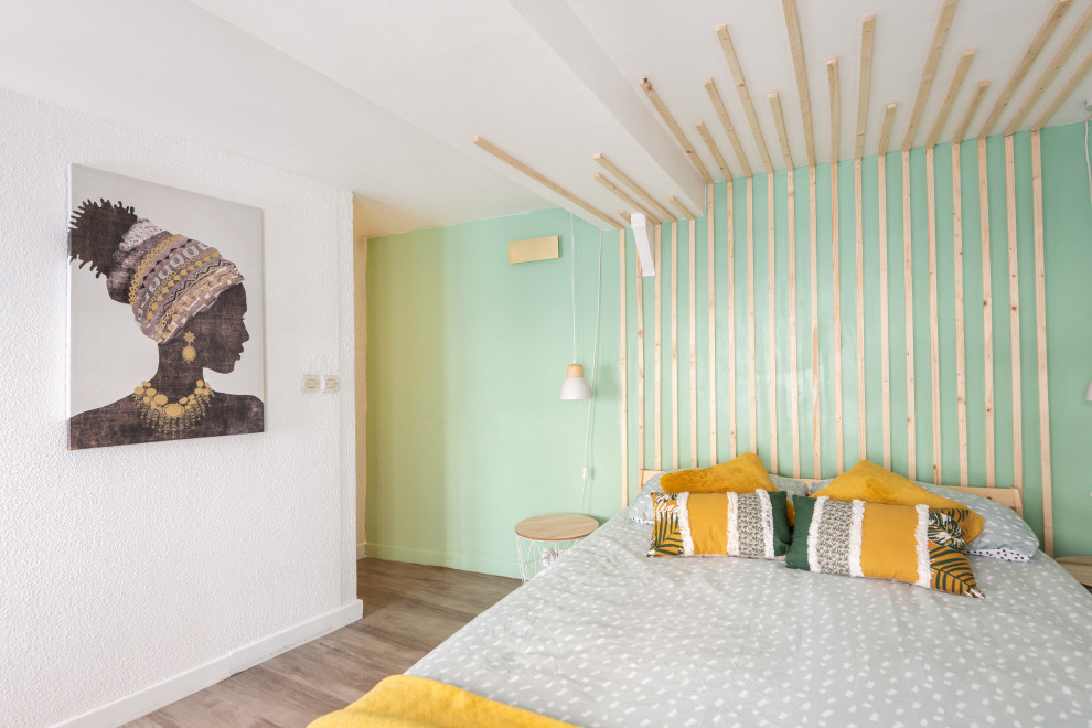 На фото: маленькая хозяйская спальня в скандинавском стиле с зелеными стенами, полом из фанеры, коричневым полом, многоуровневым потолком и обоями на стенах без камина для на участке и в саду