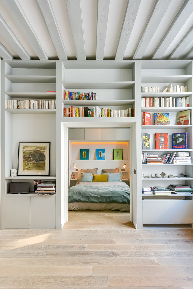 Ejemplo de dormitorio nórdico con paredes grises y suelo de madera clara
