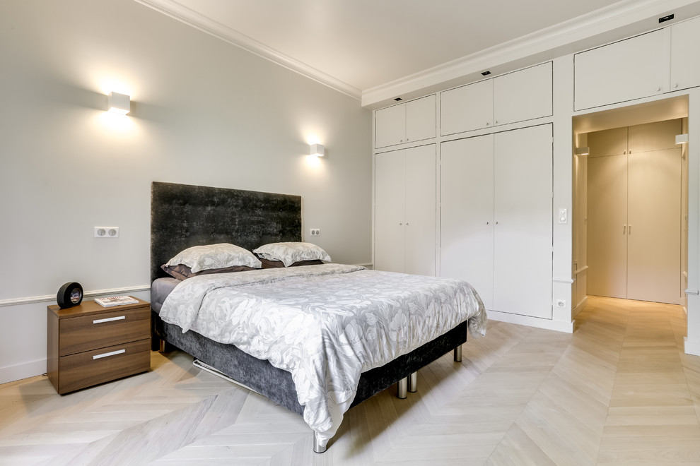 На фото: большая хозяйская спальня в современном стиле с белыми стенами, светлым паркетным полом и коричневым полом без камина