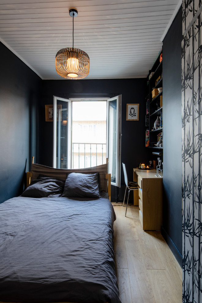 Idée de décoration pour une chambre parentale design de taille moyenne avec un mur bleu, parquet clair et un sol beige.