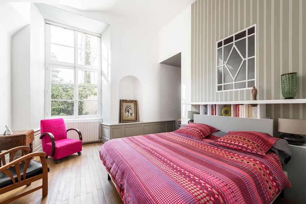 Inspiration pour une chambre d'amis design de taille moyenne avec un mur multicolore et un sol en bois brun.