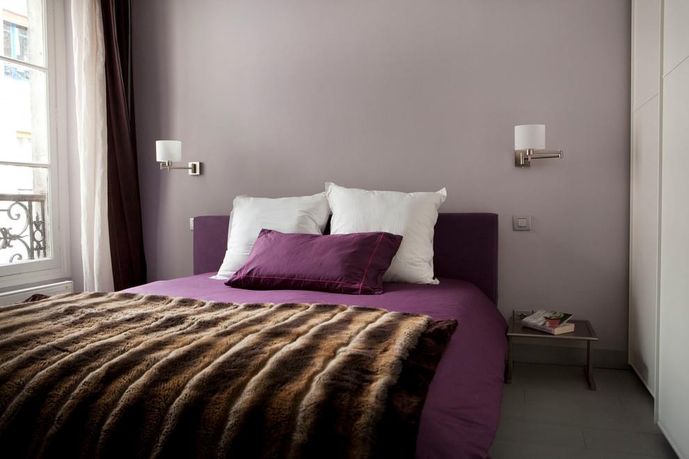 Modelo de dormitorio principal contemporáneo de tamaño medio sin chimenea con paredes púrpuras, suelo de madera pintada y suelo gris