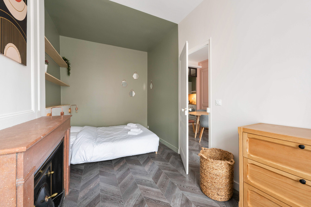 Свежая идея для дизайна: большая спальня в современном стиле с зелеными стенами, полом из ламината, стандартным камином, фасадом камина из камня и серым полом - отличное фото интерьера
