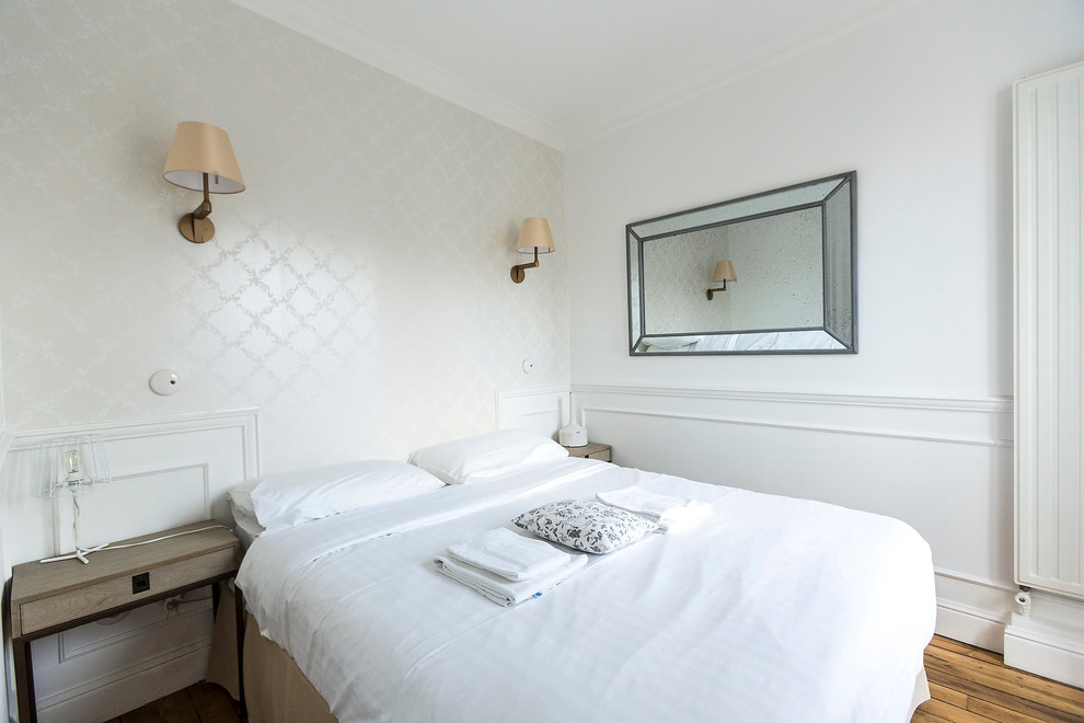 Example of a mid-sized trendy master medium tone wood floor bedroom design in Paris with white walls