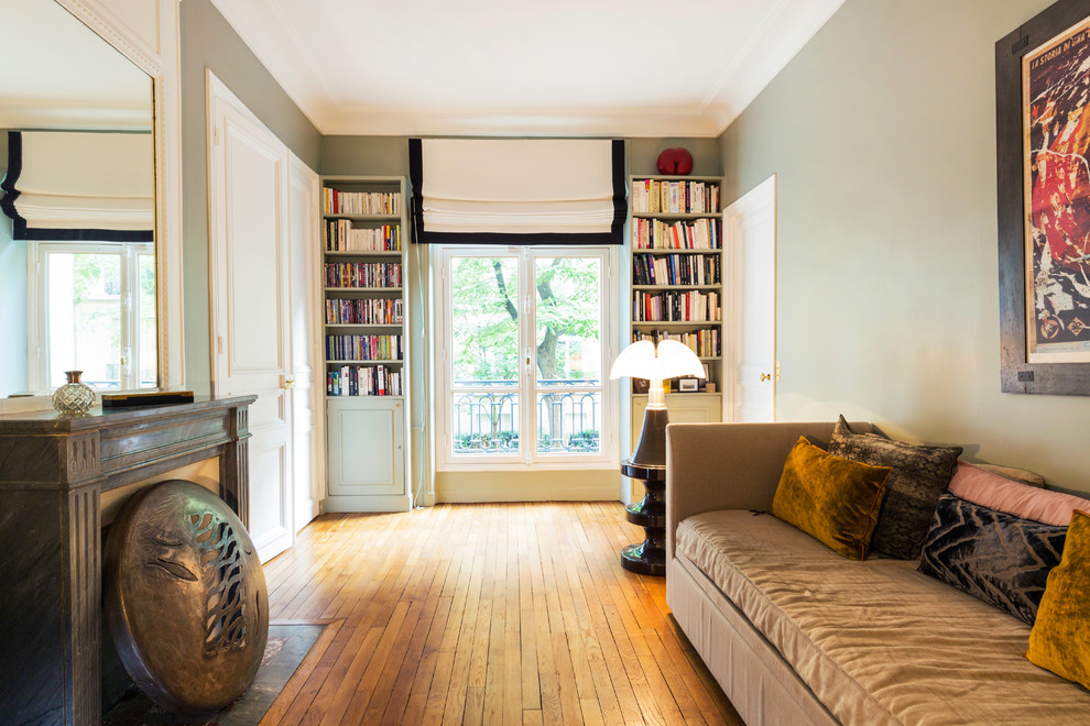 Mittelgroßes Klassisches Gästezimmer mit grüner Wandfarbe, Kamin, braunem Boden, braunem Holzboden und Kaminumrandung aus Stein in Paris