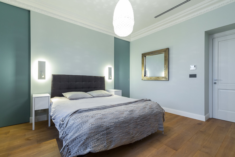 Ejemplo de dormitorio principal actual grande con paredes verdes y suelo de madera clara