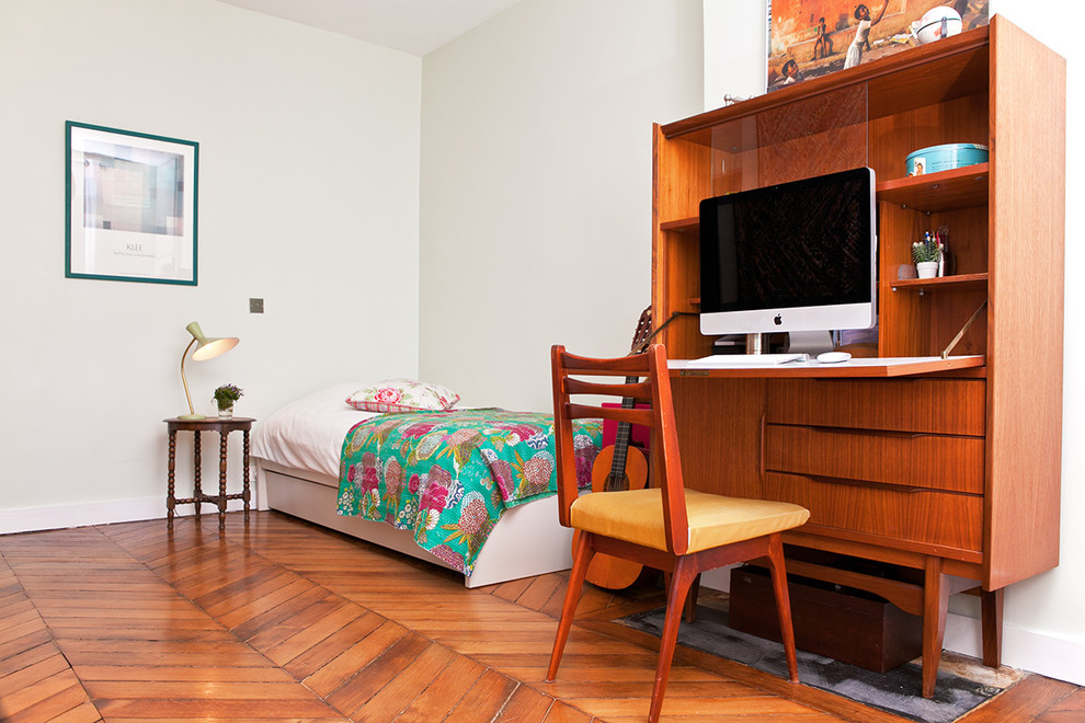 Aménagement d'une chambre d'amis classique de taille moyenne avec un mur vert, parquet foncé, une cheminée standard, un manteau de cheminée en pierre et un sol marron.