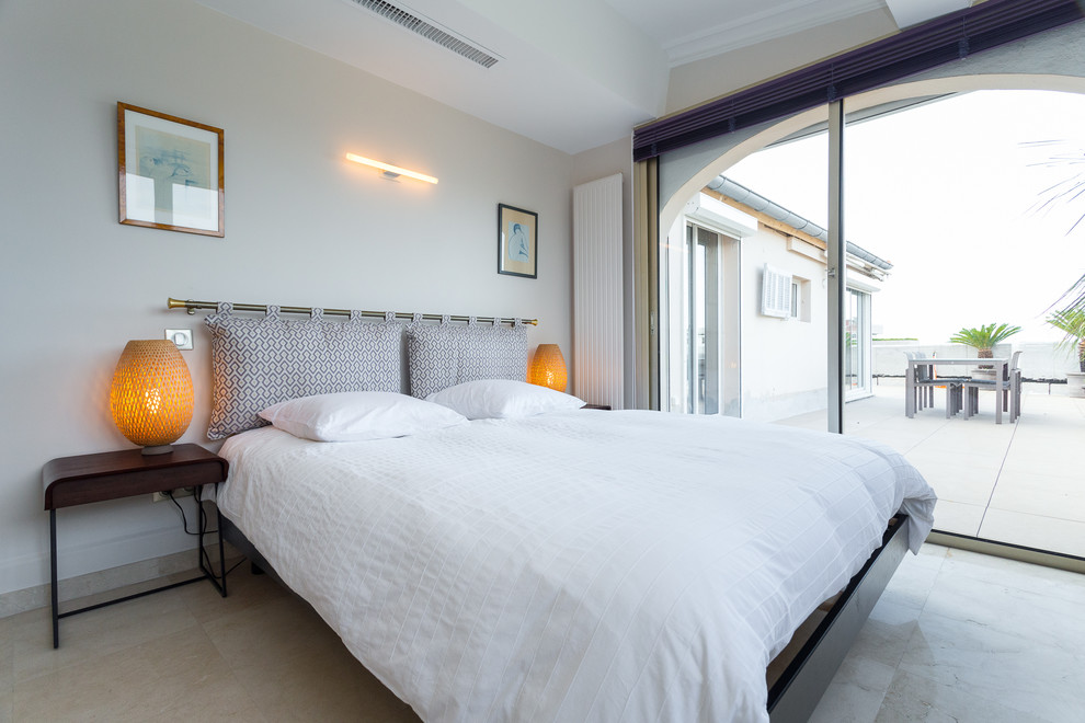 Mittelgroßes Asiatisches Hauptschlafzimmer mit weißer Wandfarbe und Travertin in Nizza