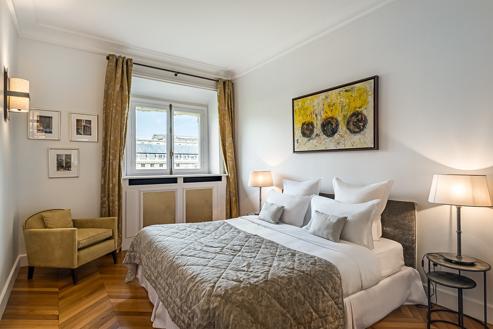 Imagen de dormitorio principal clásico renovado de tamaño medio con paredes blancas y suelo de madera clara