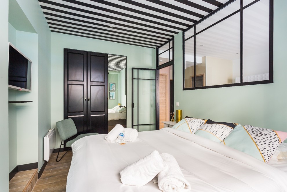 Modelo de dormitorio principal minimalista de tamaño medio con paredes verdes, suelo de baldosas de cerámica y suelo marrón