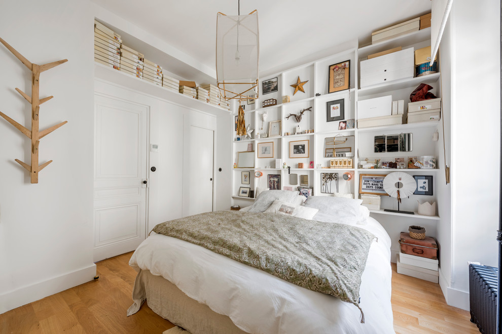 Imagen de dormitorio principal y blanco y madera ecléctico sin chimenea con paredes blancas y suelo de madera en tonos medios