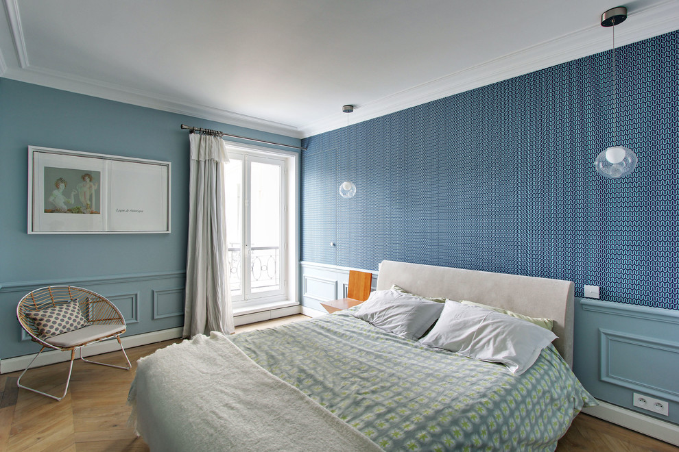 Imagen de dormitorio principal clásico renovado de tamaño medio sin chimenea con paredes azules y suelo de madera clara