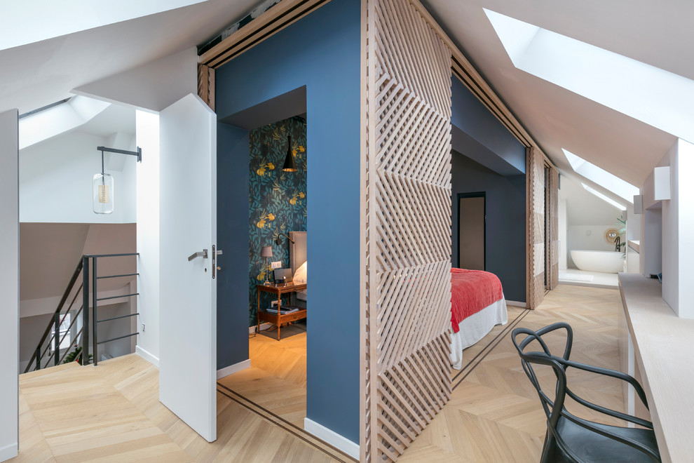Modernes Hauptschlafzimmer mit blauer Wandfarbe, hellem Holzboden und beigem Boden in Paris