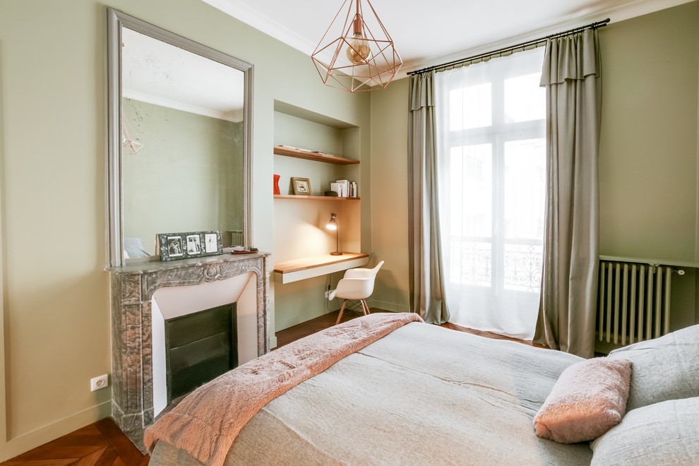 Großes Modernes Hauptschlafzimmer mit grüner Wandfarbe, braunem Holzboden, Kamin, Kaminumrandung aus Stein und braunem Boden in Paris