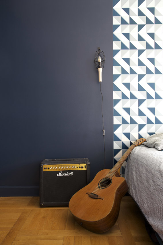 Réalisation d'une chambre parentale nordique de taille moyenne avec un mur bleu, un sol en bois brun et un sol beige.