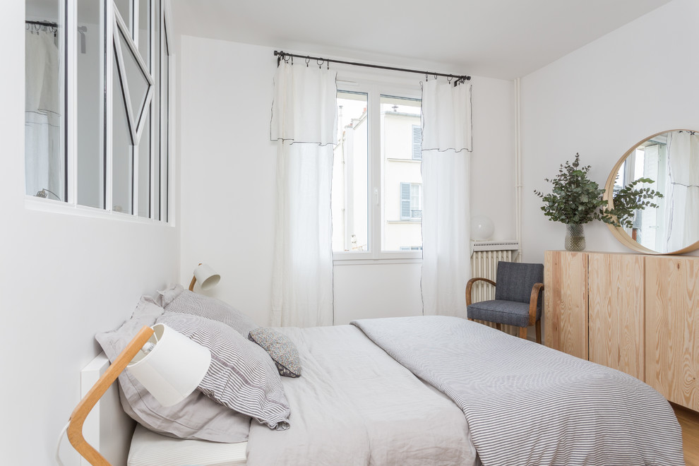 Foto de dormitorio principal y blanco y madera escandinavo de tamaño medio sin chimenea con paredes blancas, suelo de madera clara y suelo beige