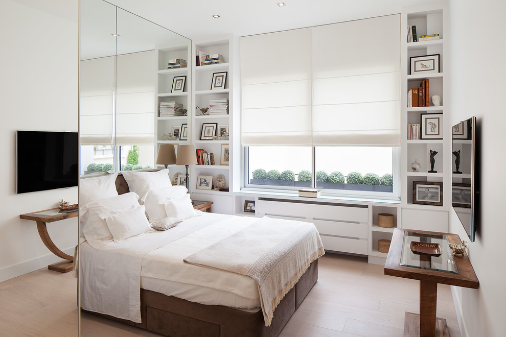 Diseño de dormitorio principal y televisión contemporáneo de tamaño medio con paredes blancas y suelo de madera clara