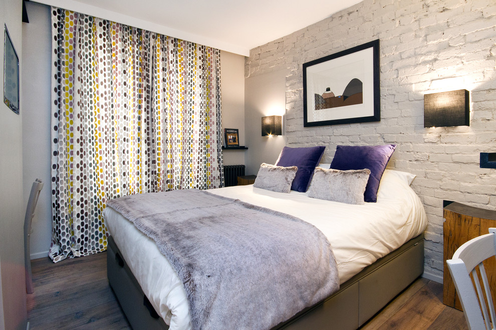 Diseño de dormitorio principal actual de tamaño medio con paredes blancas y suelo de madera en tonos medios