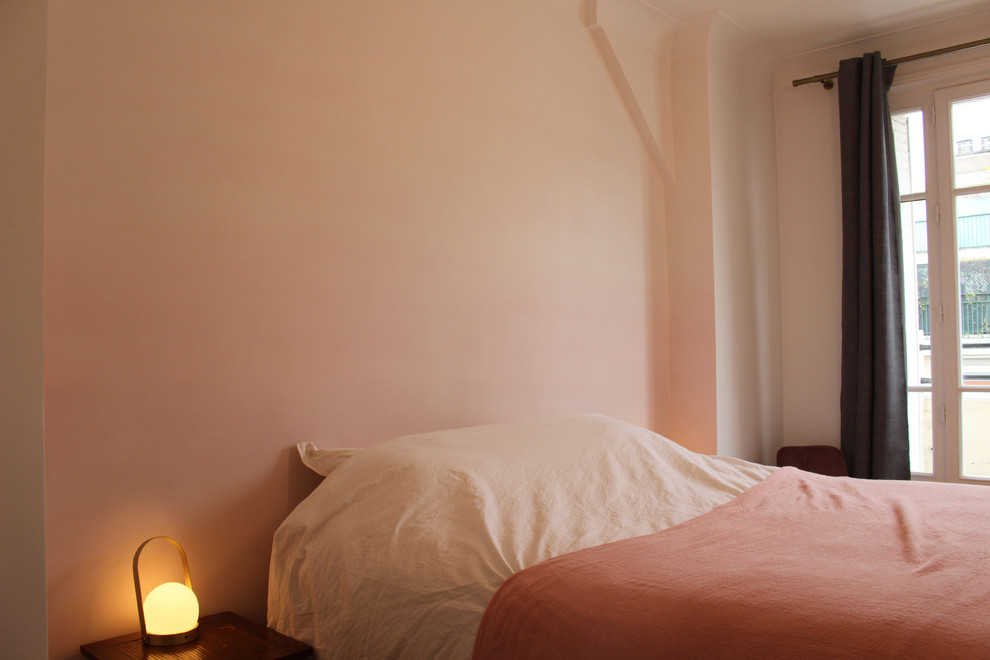Modelo de dormitorio principal clásico renovado de tamaño medio con paredes rosas, suelo de madera clara y suelo marrón