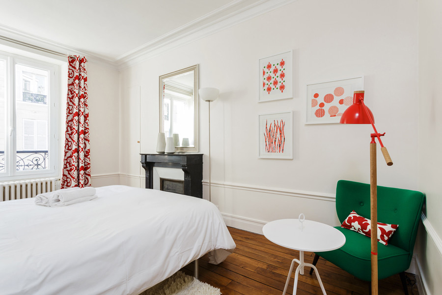 Cette image montre une chambre d'amis design de taille moyenne avec parquet foncé, une cheminée standard et un sol marron.