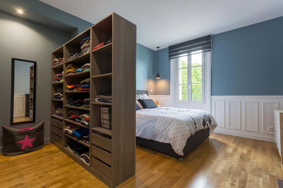 Example of a large trendy master light wood floor and brown floor bedroom design in Paris with blue walls and no fireplace