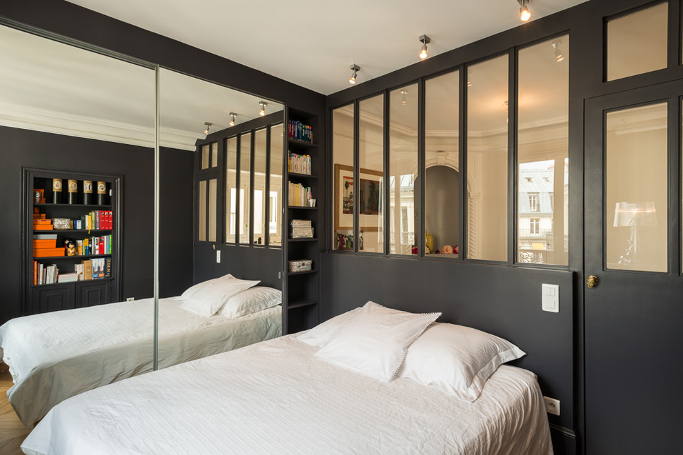Foto de dormitorio principal actual de tamaño medio con paredes negras, suelo de madera en tonos medios y suelo marrón