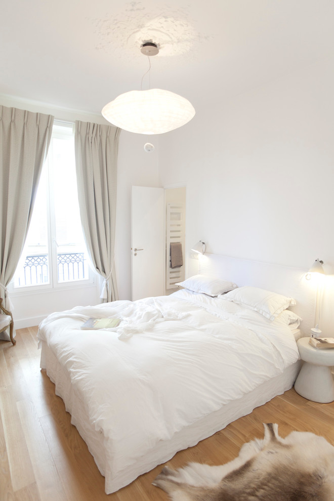 Mittelgroßes Modernes Gästezimmer ohne Kamin mit weißer Wandfarbe, braunem Holzboden und braunem Boden in Paris