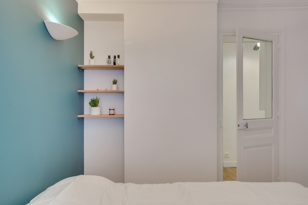 Exemple d'une chambre parentale moderne de taille moyenne avec un mur bleu, parquet clair et aucune cheminée.