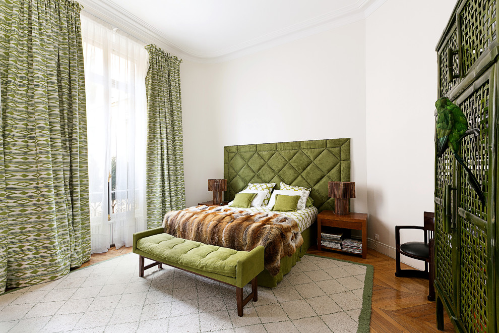 Aménagement d'une chambre d'amis classique avec un mur blanc et un sol en bois brun.