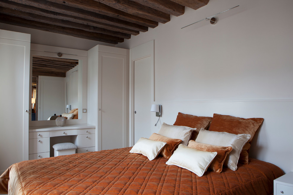 Exemple d'une petite chambre parentale chic avec un mur beige, parquet foncé, aucune cheminée et un sol marron.