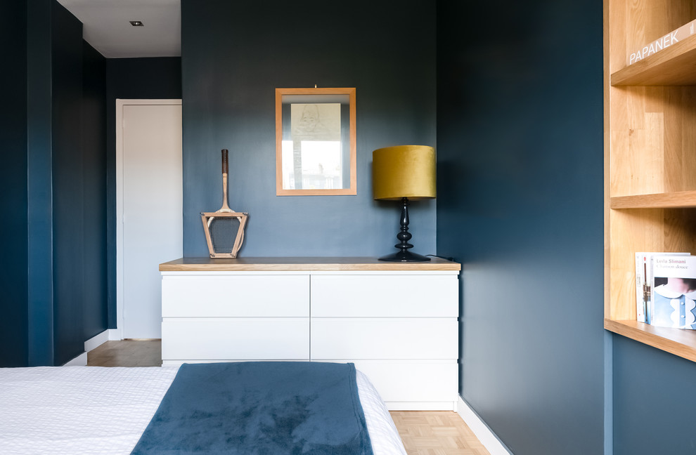 Réalisation d'une chambre parentale design de taille moyenne avec un mur bleu, parquet clair, aucune cheminée et un sol beige.