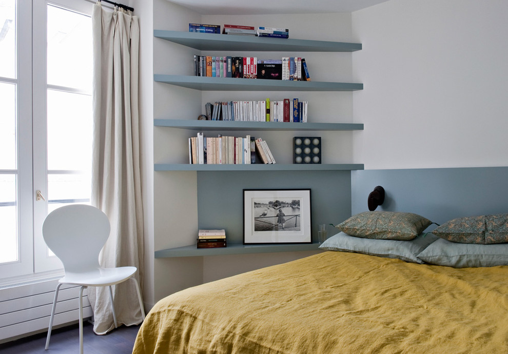 Idée de décoration pour une chambre parentale beige et marron design de taille moyenne avec un mur multicolore et un sol en bois foncé.