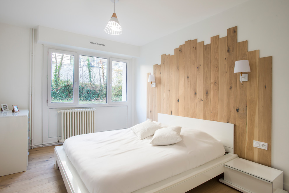 Ejemplo de dormitorio escandinavo sin chimenea con paredes blancas y suelo de madera clara