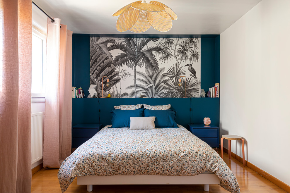 Cette image montre une chambre design avec un mur bleu, un sol en bois brun et un sol marron.