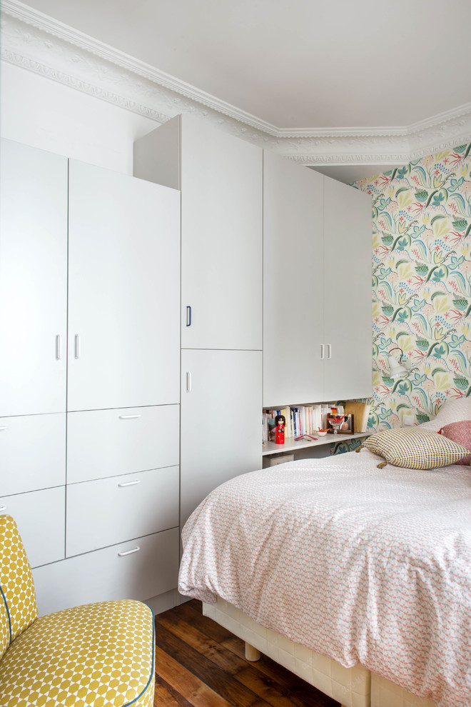 Kleines Nordisches Hauptschlafzimmer mit bunten Wänden, dunklem Holzboden, braunem Boden und Tapetenwänden in Paris