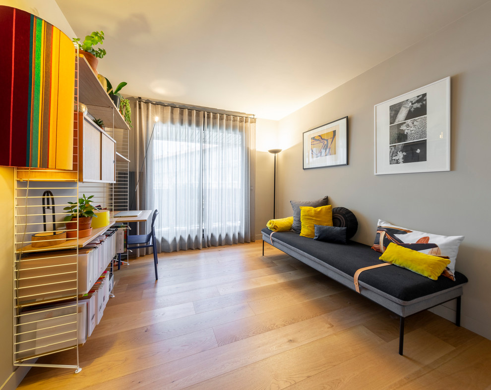 Aménagement d'une chambre d'amis moderne de taille moyenne avec un mur beige, parquet clair, aucune cheminée et un sol marron.