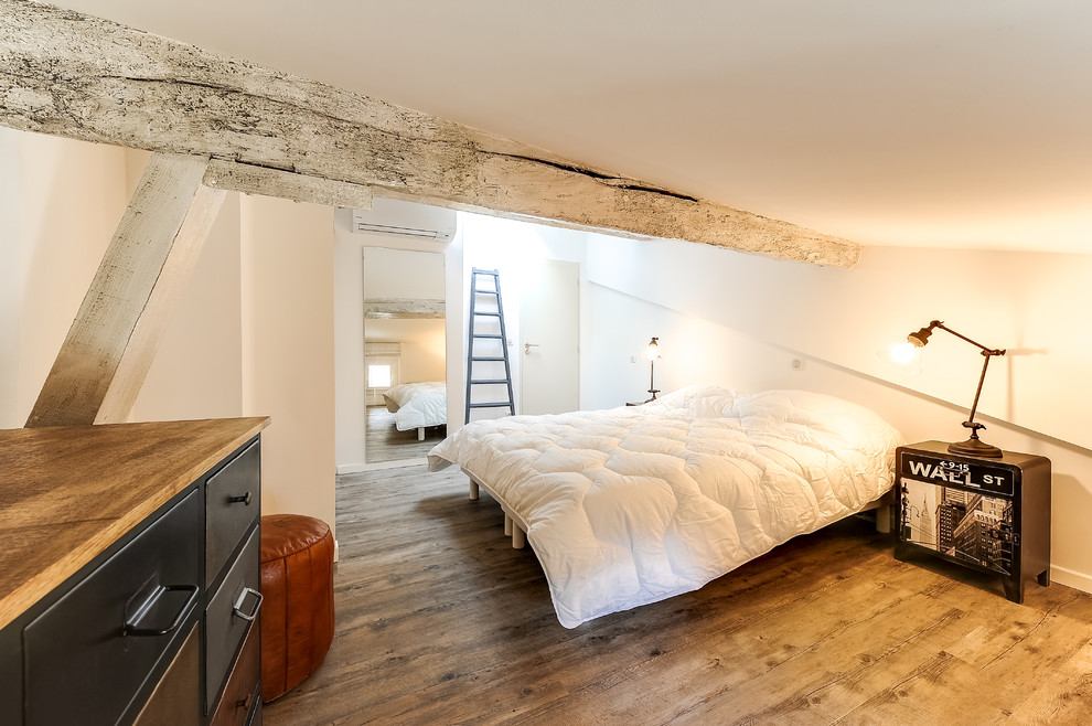 Foto på ett litet funkis sovloft, med vita väggar och ljust trägolv