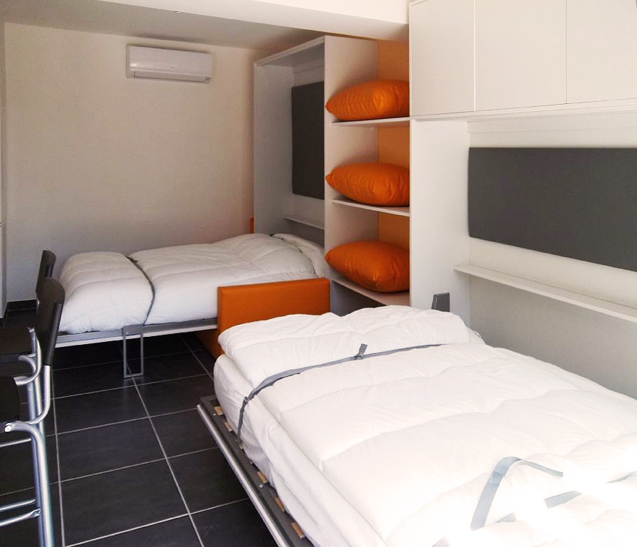Imagen de dormitorio principal actual pequeño con parades naranjas y suelo de baldosas de cerámica