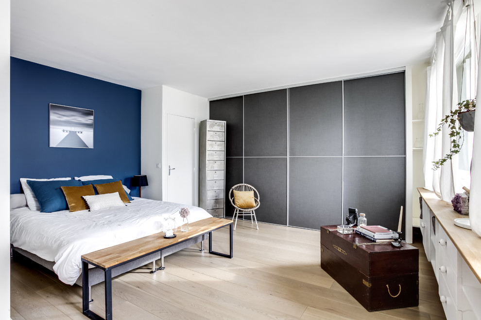 Foto de dormitorio principal nórdico con paredes azules, suelo de madera clara y suelo beige