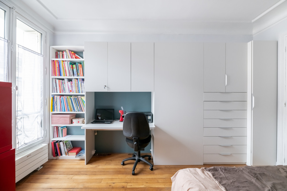 Mittelgroßes Modernes Hauptschlafzimmer mit weißer Wandfarbe, braunem Holzboden und braunem Boden in Paris