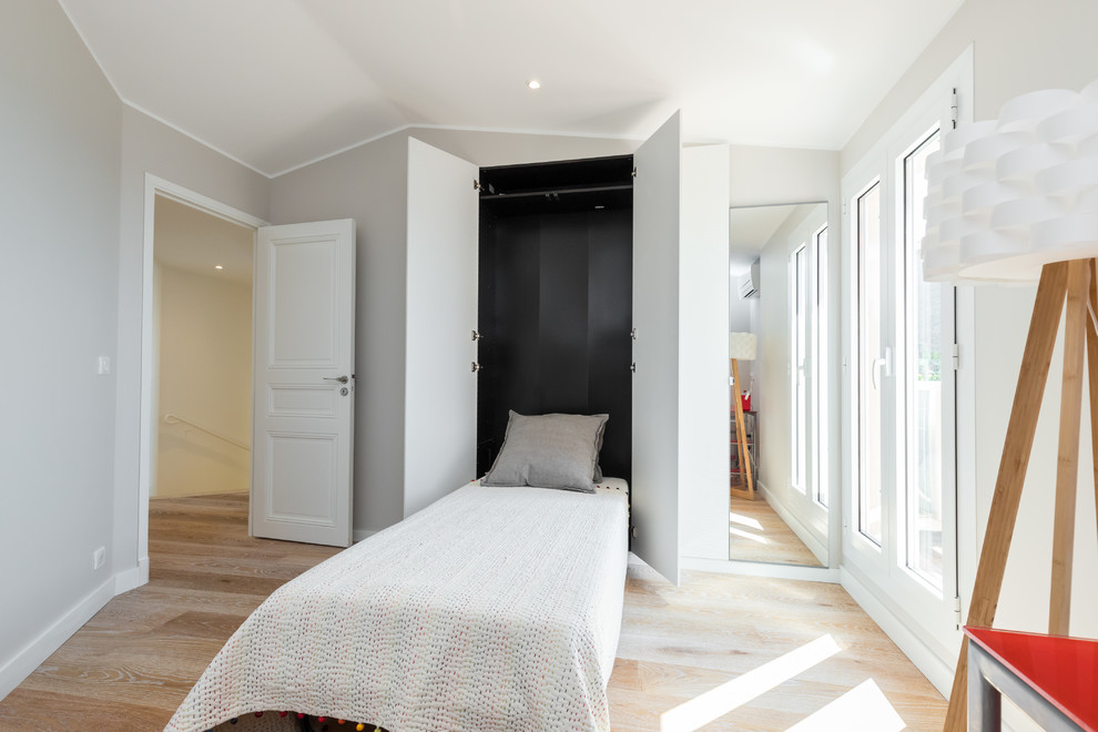 Foto de habitación de invitados actual pequeña con paredes beige, suelo de contrachapado y suelo beige