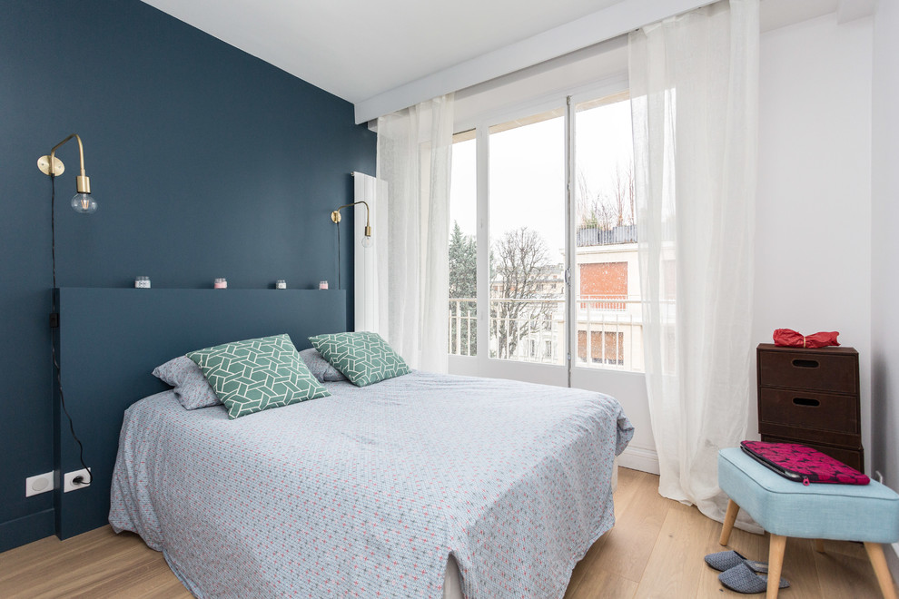 Idées déco pour une chambre d'amis scandinave avec un mur bleu, parquet clair et un sol beige.