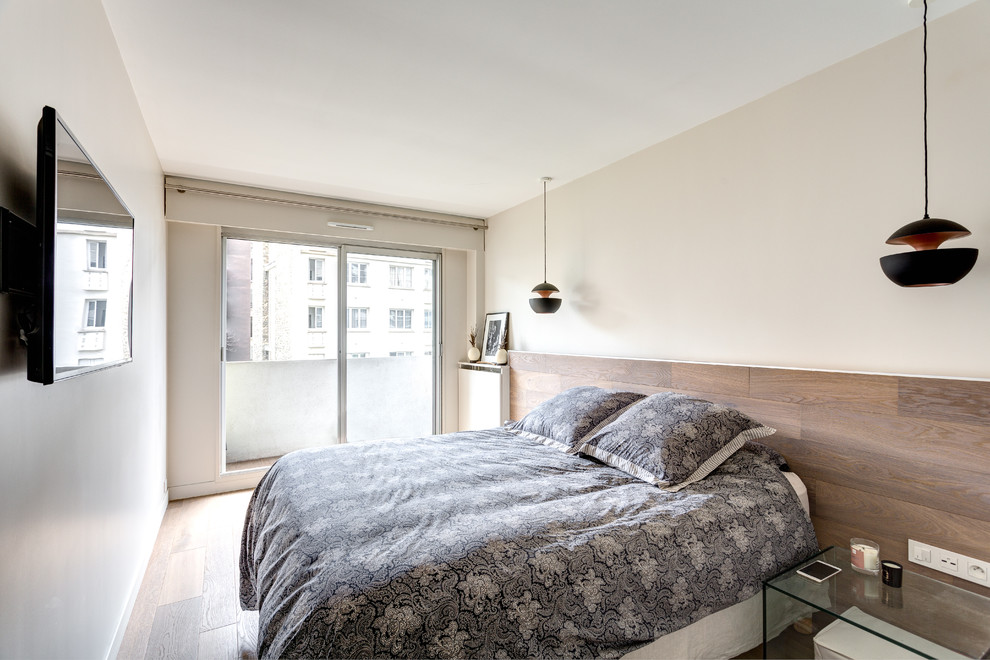 Modelo de dormitorio principal contemporáneo con paredes blancas, suelo de madera en tonos medios y suelo beige
