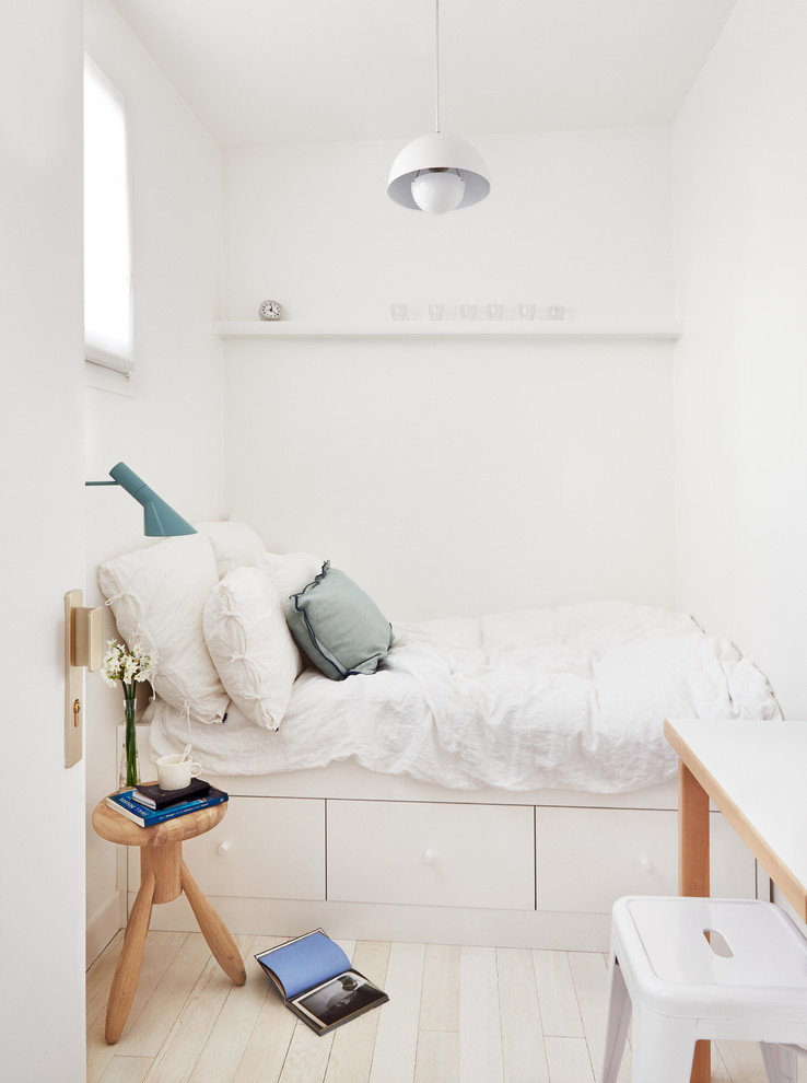 Kleines Nordisches Hauptschlafzimmer ohne Kamin mit weißer Wandfarbe und hellem Holzboden in Paris