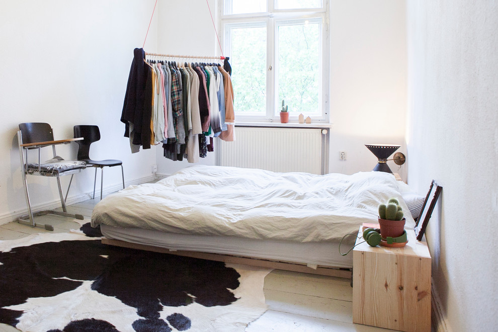 Mittelgroßes Skandinavisches Hauptschlafzimmer ohne Kamin mit weißer Wandfarbe und gebeiztem Holzboden in Berlin