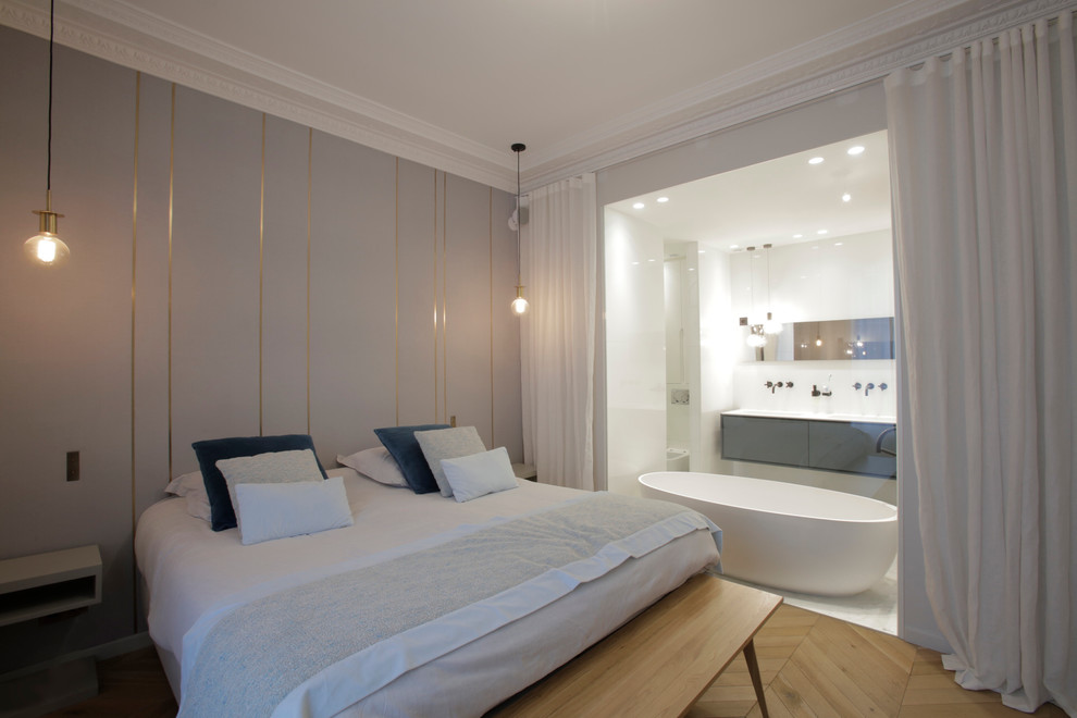 Example of a large trendy master light wood floor bedroom design in Paris with gray walls and no fireplace