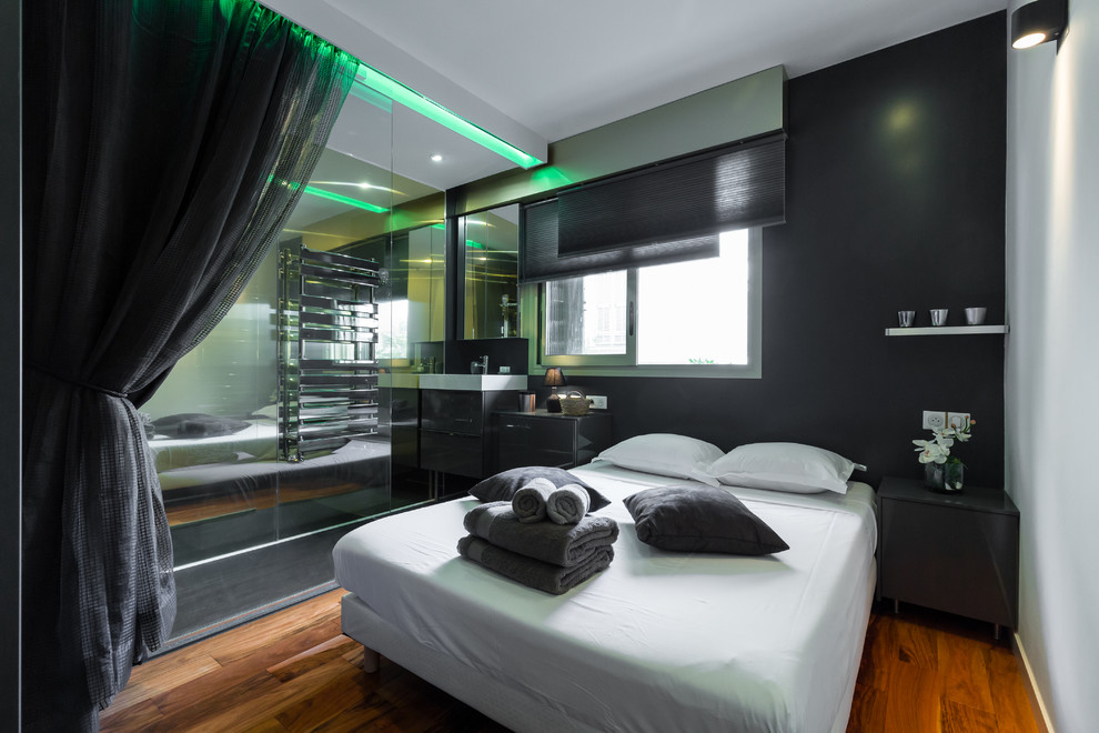 Diseño de dormitorio principal contemporáneo de tamaño medio con paredes negras y suelo de madera en tonos medios