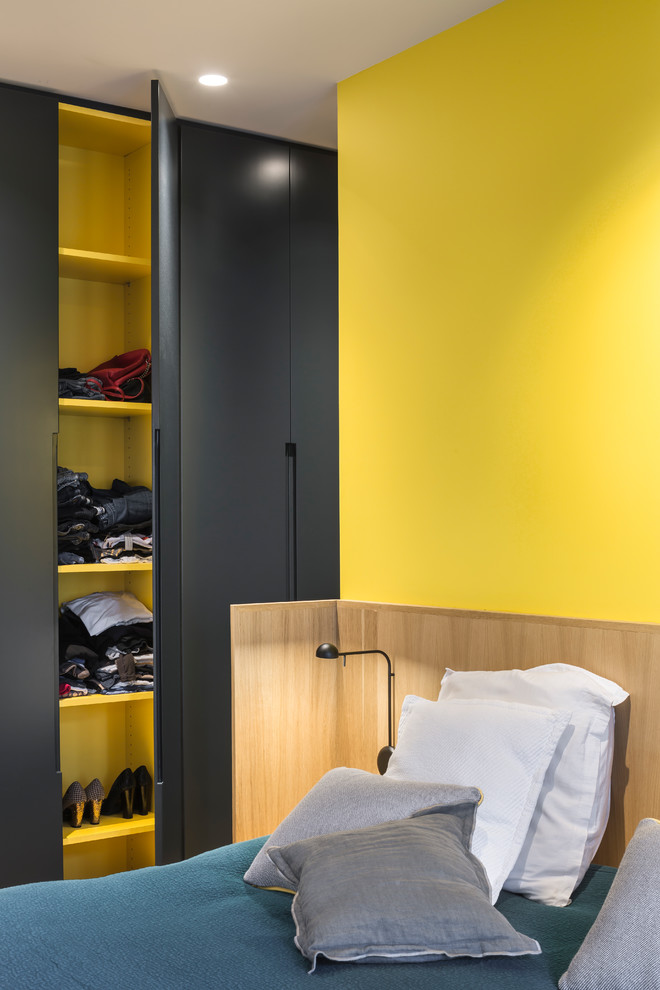 Foto de dormitorio principal contemporáneo de tamaño medio con paredes amarillas y suelo de madera clara